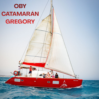 OBY CATAMARAN GREGORY Catamarán rojo navegando en aguas azules, con varias personas a bordo.
